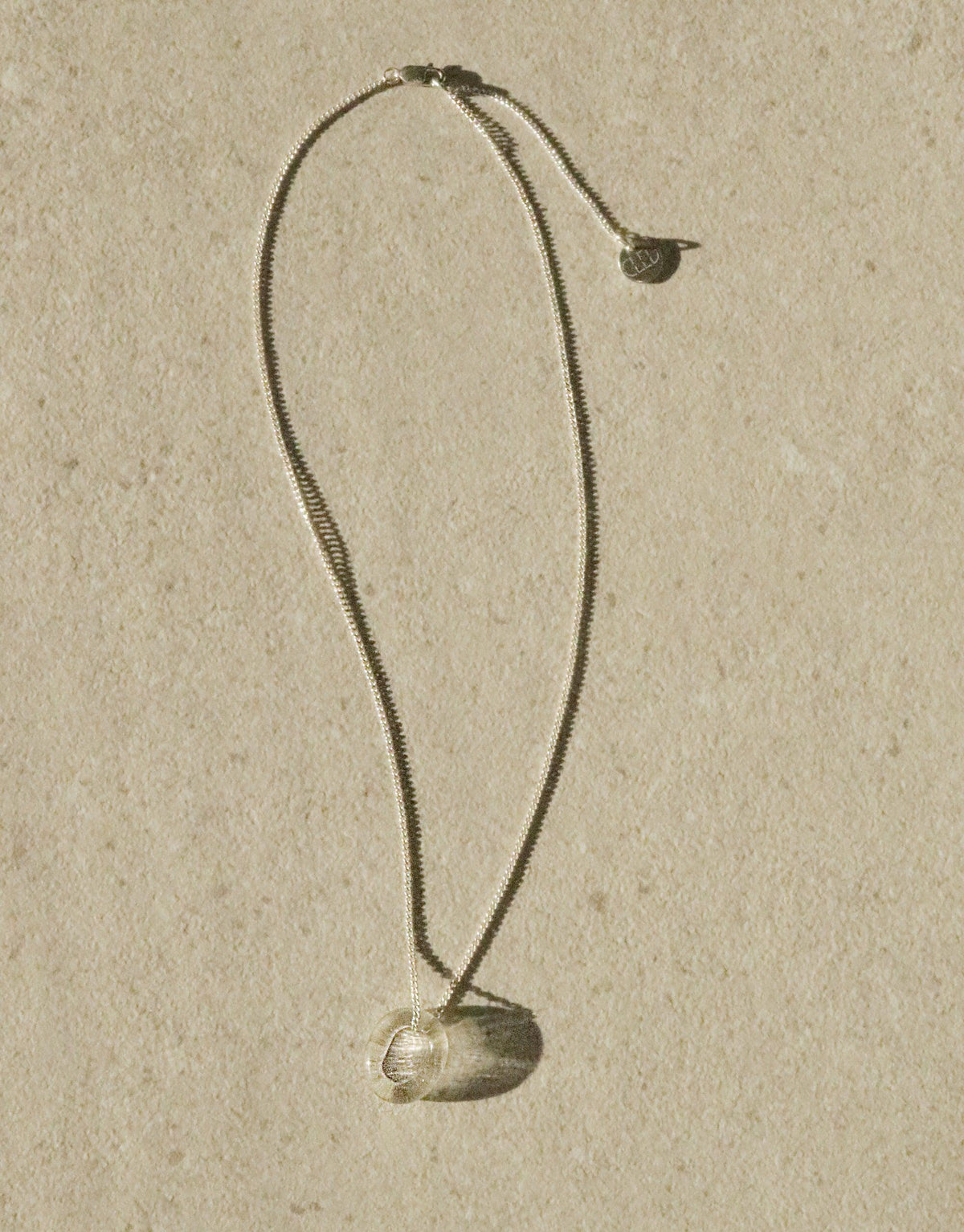 Elegant In The Loop Necklace featuring a delicate curb chain and minimalist eco-friendly glass pendant, showcasing sustainable luxury in a sleek design. Adjustable length for versatile styling. Handcrafted with care by CLED.