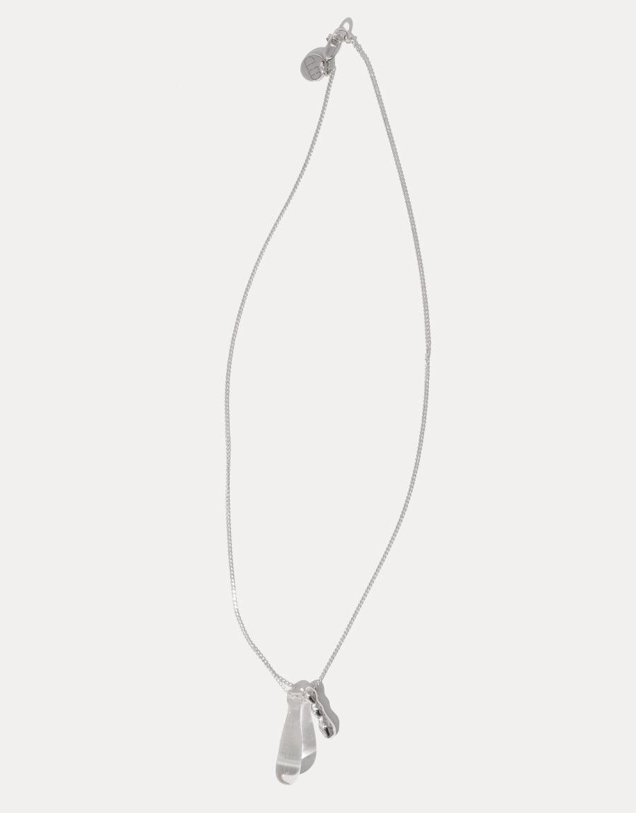Drop Counts Necklace featuring a delicate silver chain with a translucent glass water drop pendant and wavy metal charm. Eco-friendly jewelry made from repurposed glass bottles, symbolizing the importance of water conservation. Handcrafted sterling silver necklace by CLED.