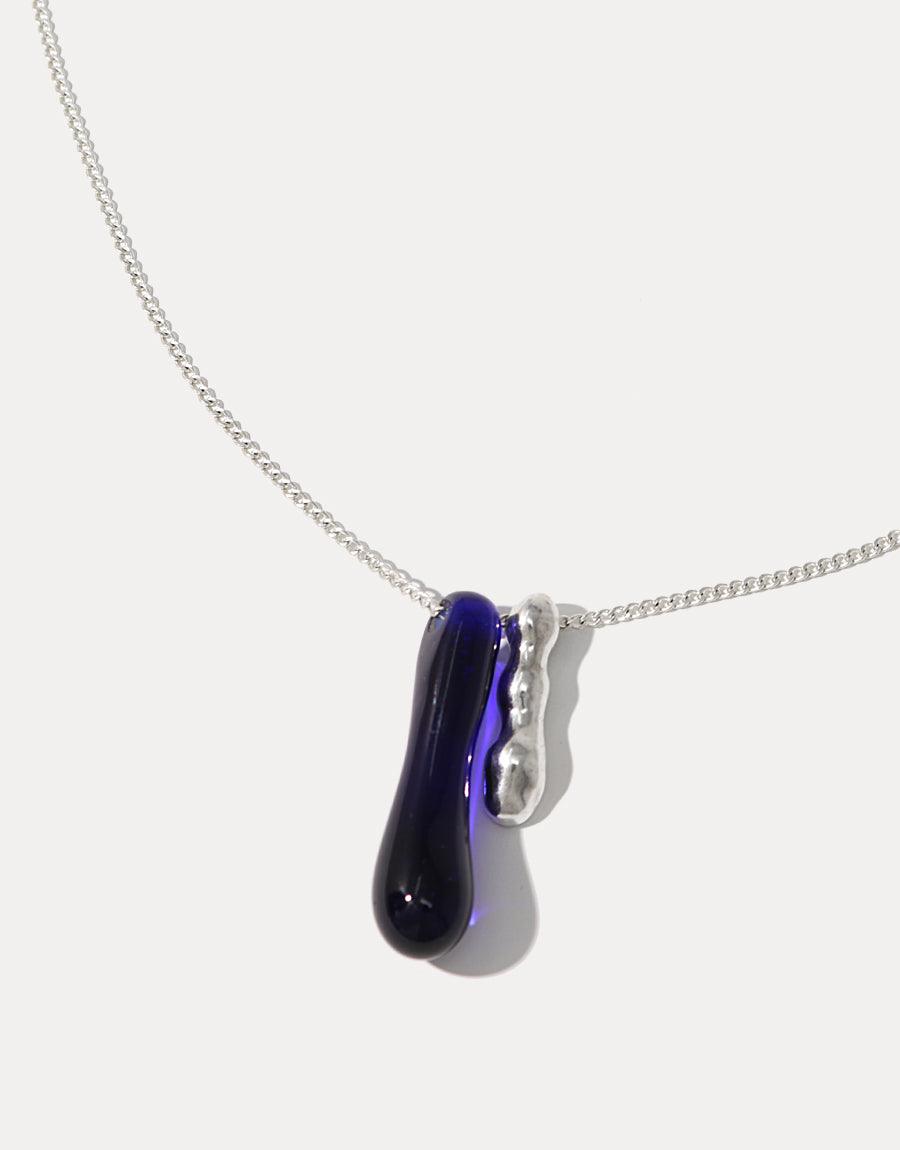 Sterling silver necklace featuring a deep blue glass water drop pendant and wavy metal accent, symbolizing the importance of water conservation. Handcrafted eco-friendly jewelry. Drop Counts Necklace by CLED.