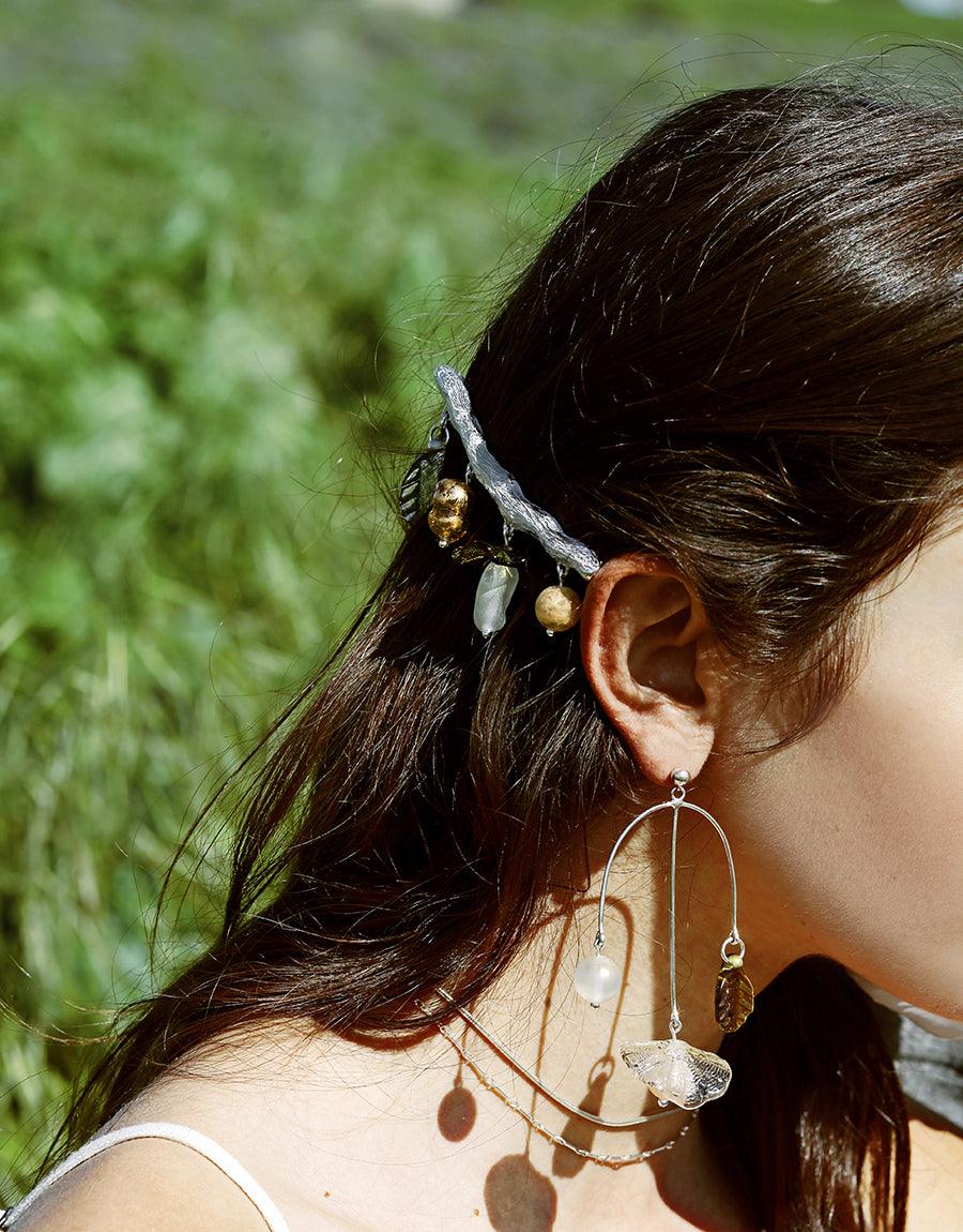 Close-up of Floral Barrette adorning dark hair, showcasing delicate spring-inspired design with eco-friendly glass elements. Sterling silver barrette paired with matching earrings, highlighting sustainable beauty in a natural outdoor setting. Handcrafted Floral Barrette by CLED