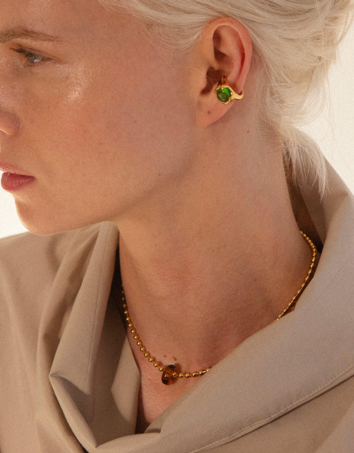 Close-up of model wearing gold Donut Ball Necklace with eco-friendly glass pendant, showcasing elegant design and sustainable materials. Complemented by matching earrings, perfect for eco-conscious fashion lovers. Handcrafted jewelry by CLED.
