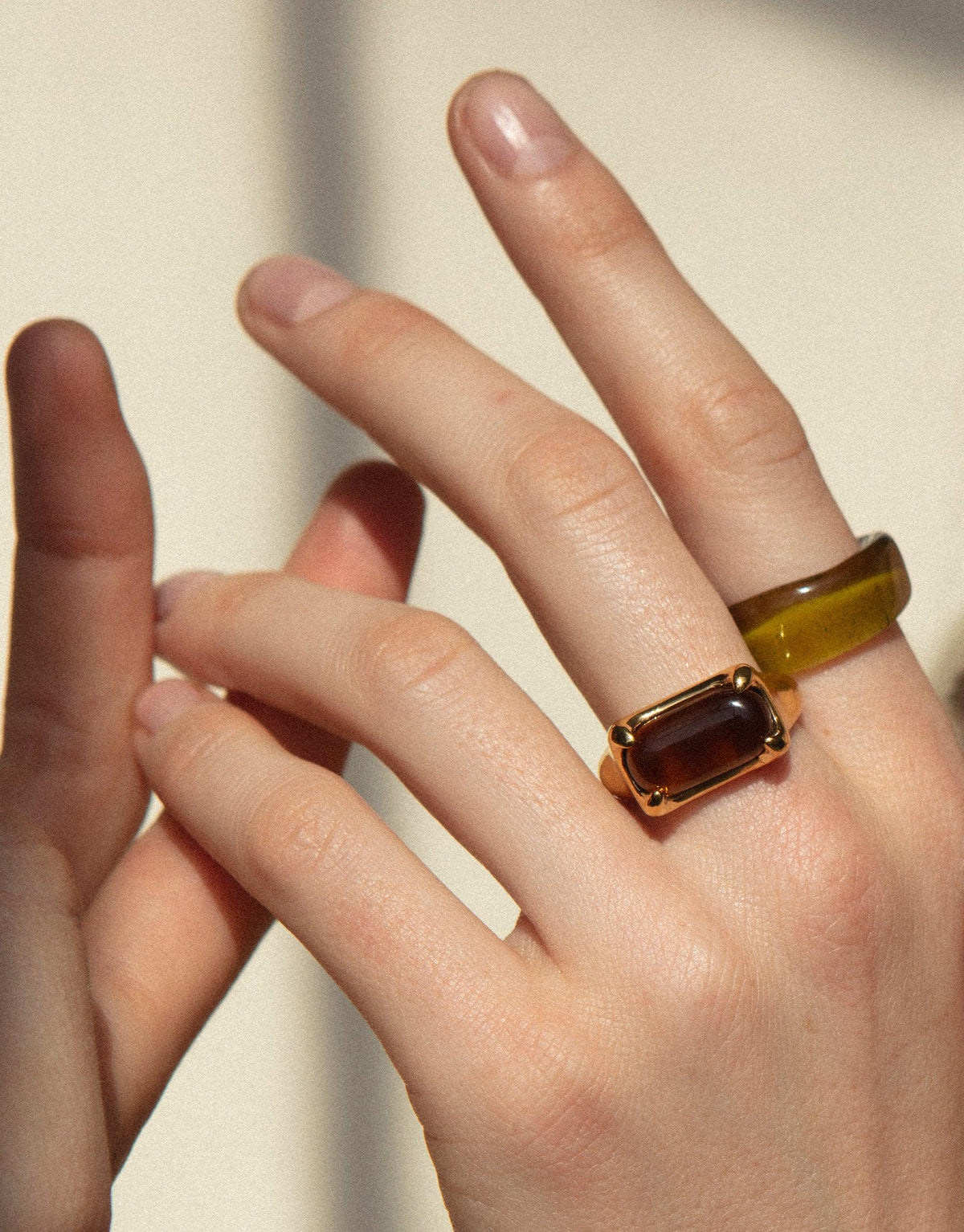 Hand wearing Prism Ring in Sterling Silver, featuring a rectangular eco gem upcycled from discarded glass. The ring catches light, creating a prism-like effect reminiscent of a rainbow. Handcrafted by CLED, this unique piece showcases sustainable jewelry design. Prism Ring | Sterling Silver by CLED